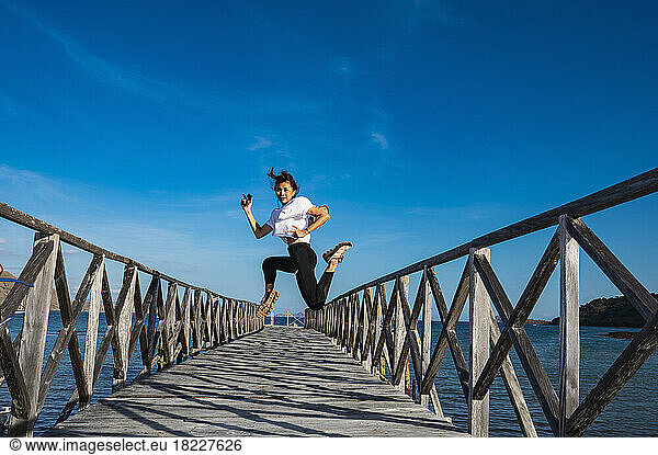 woman jumping on a pier at east Nusa Tenggara island in Komodo