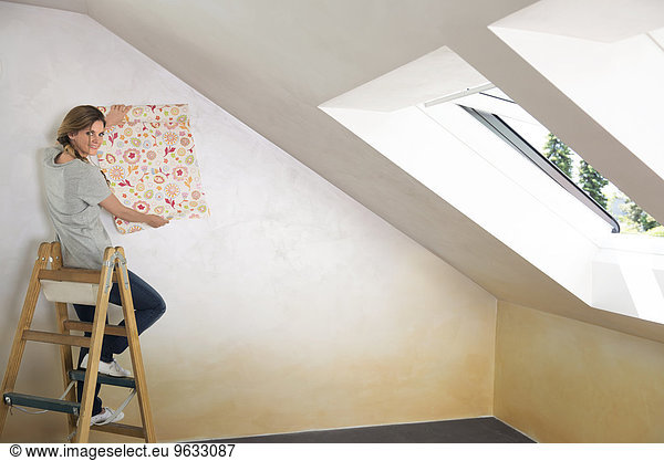 Woman ladder sitting holding wallpaper pattern
