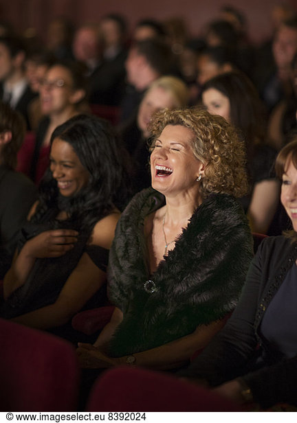 Woman laughing enthusiastically in theater audience