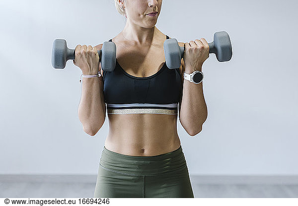 Woman lifting dumbbells in gym