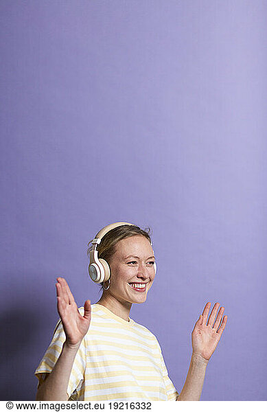 Woman listening music on headphones and enjoying dance in studio
