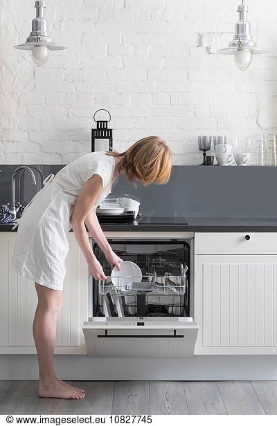 Woman loading dishes into dishwasher