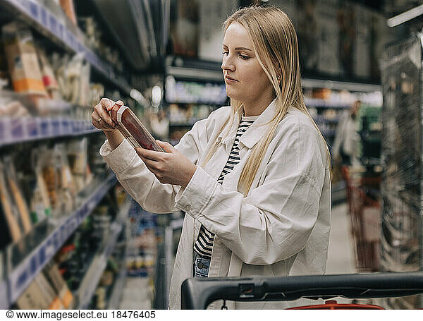 Woman looking at food packing in supermarket