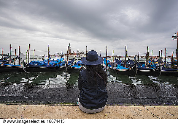 woman looking at gondolas in the Venice Lagoon  Venice  Italy