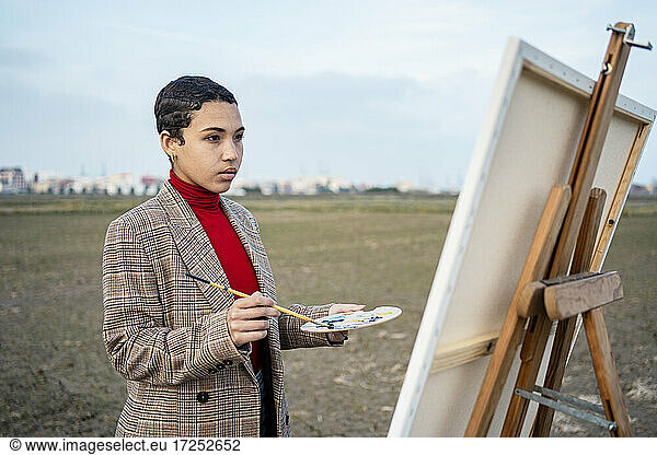 Woman looking at painting at countryside.