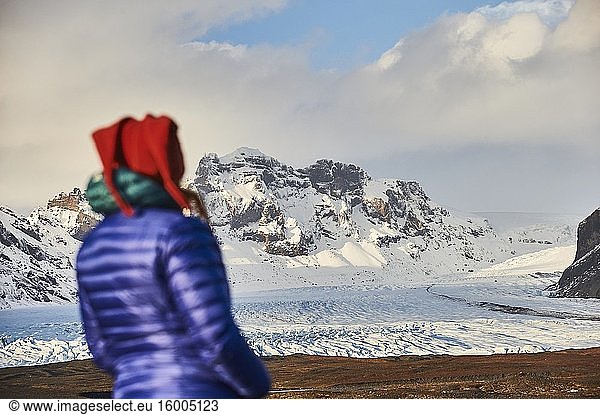 Woman looking at Skaftafellsjokull  this is a glacier tongue spurting off from Iceland's largest ice cap  Vatnajokull (region of Austurland  Iceland).