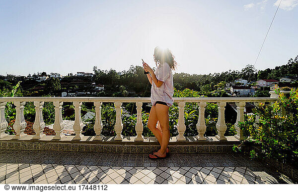 woman looking at the mobile in a viewpoint tells the sunset
