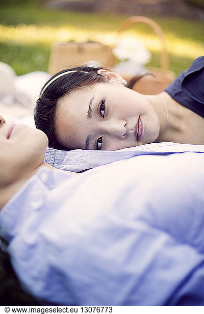 Woman looking away while relaxing on boyfriend's chest
