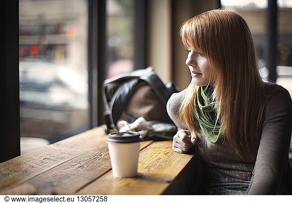 Woman looking down while sitting in cafe
