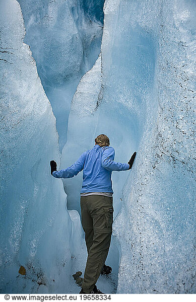 Woman looking into chasm in glacier near McCarthy  Alaska.