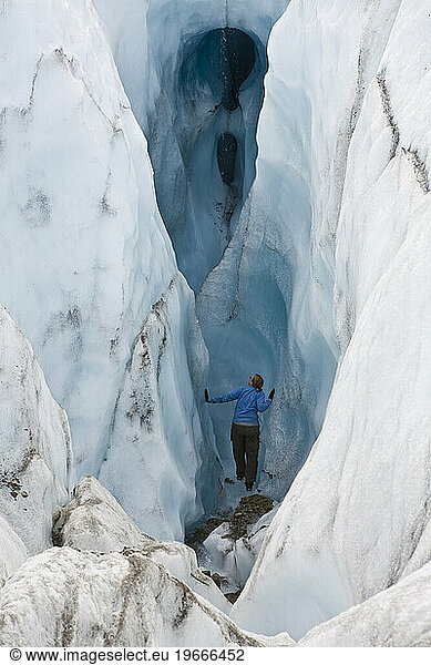 Woman looking into chasm in glacier near McCarthy  Alaska.