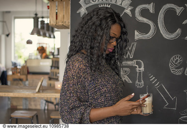 Woman looking worried at her smartphone in a cafe