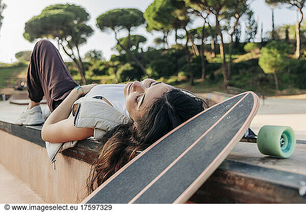Woman lying by skateboard in park