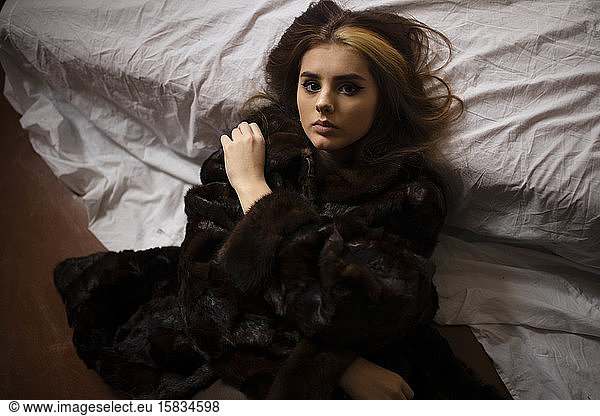 Woman lying in a fur coat