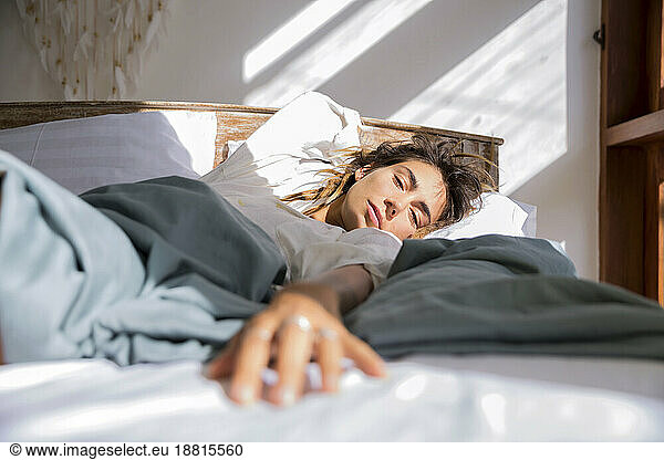 Woman lying on bed at home