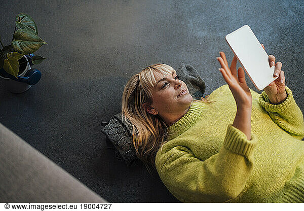 Woman lying on floor and using tablet PC at home