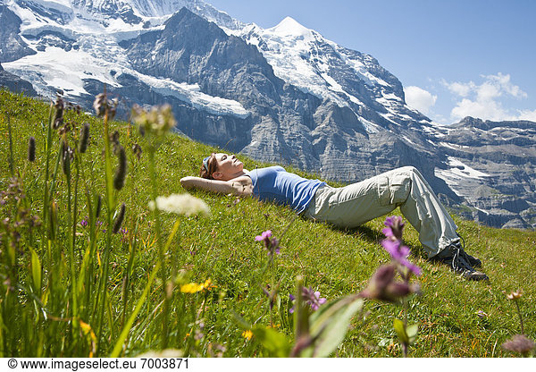 Woman Lying on Grass on Mountain Side  Bernese Oberland  Switzerland