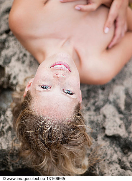 woman lying on rocks looking at viewer