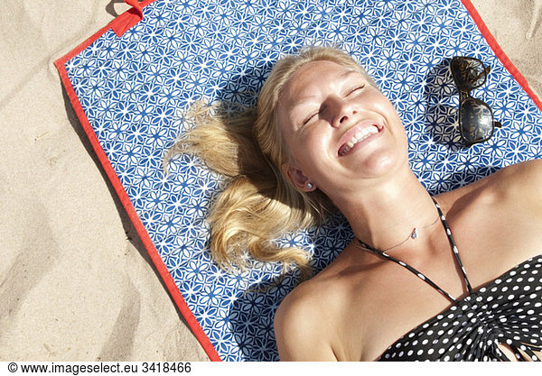 Woman lying on the beach sunbathing