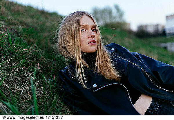 woman lying on the grass in a leather jacket