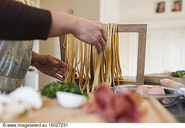 Woman making fresh homemade pasta in kitchen