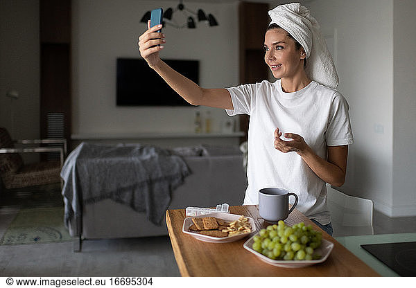 Woman making video call to friends in morning