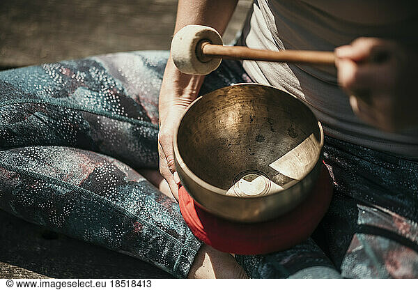 Woman meditating with Tibetan singing bowl