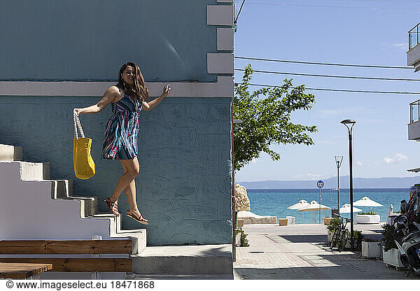 Woman moving down on steps near building on vacation