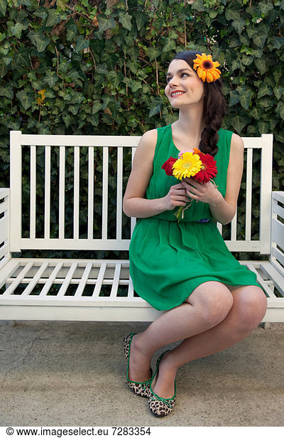 Woman on bench holding flowers