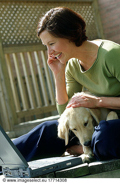 Woman On Phone With Laptop And Puppy