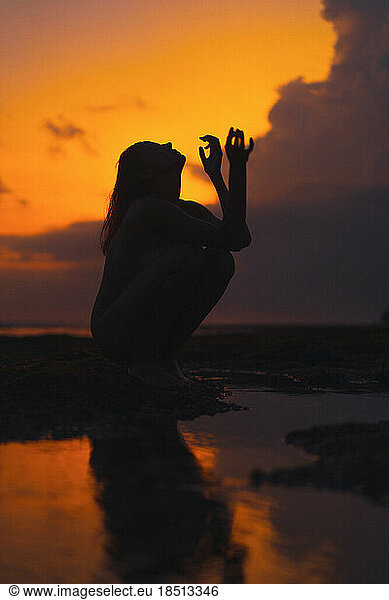 Woman on the ocean at a bright sunset.