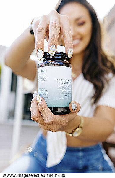 Woman opening lid of medicine bottle