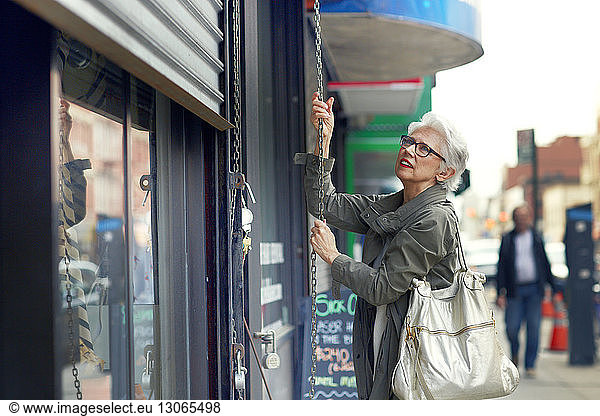 Woman opening store shutter