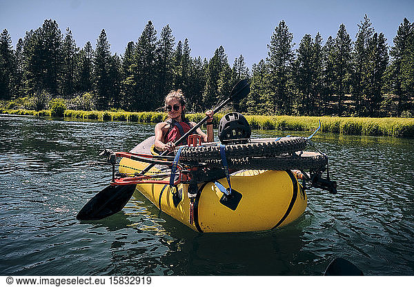 Woman paddles on the Deschutes River in a pack raft in Oregon.