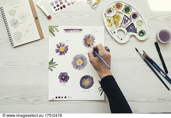 Woman painting flowers with water colors  top view