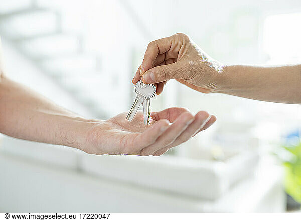 Woman passing keys to man