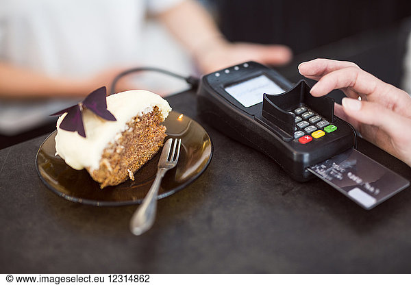 Woman paying for cake with credit card