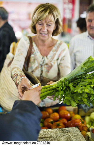 Woman paying for vegetables at market