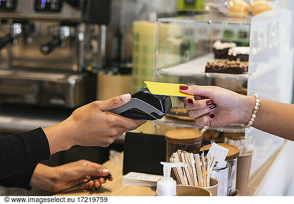 Woman paying through credit card at cafe