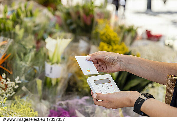 Woman paying through credit card at flower shop