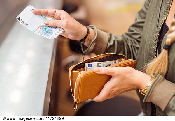 Woman paying with cash at bar