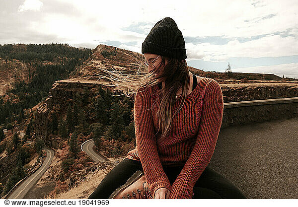 Woman perched above the Rowena Crest Viewpoint