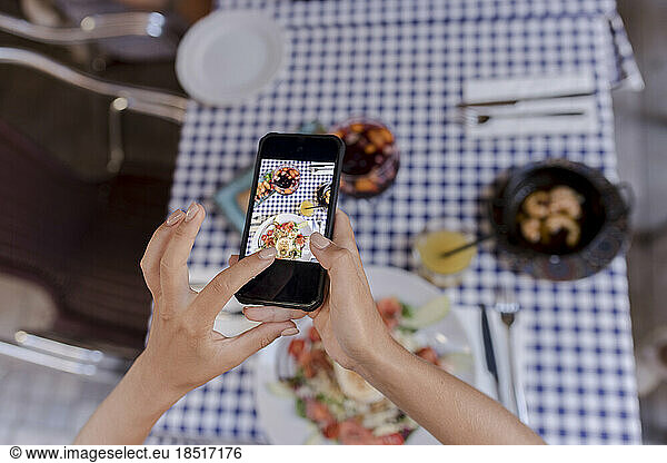 Woman photographing food through smart phone