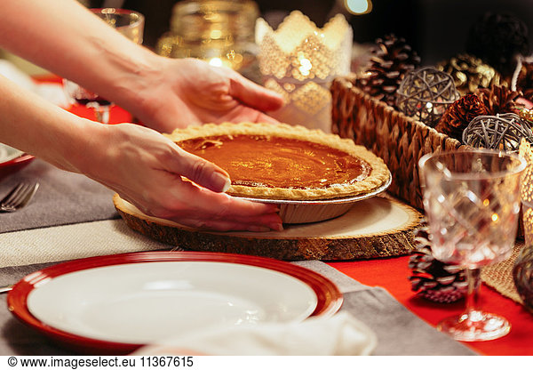 Woman placing pie on festive table
