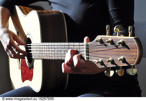 Woman playing a western guitar
