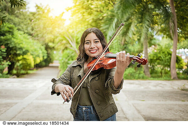Woman playing the violin outdoors. Girl playing the violin outdoors