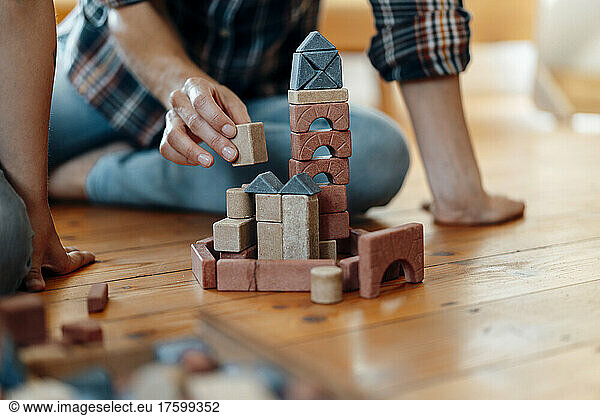 Woman playing toy blocks on floor at home