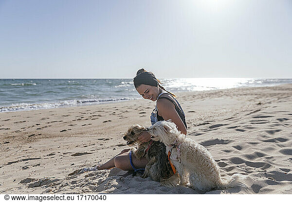 Woman playing with her dogs on beach