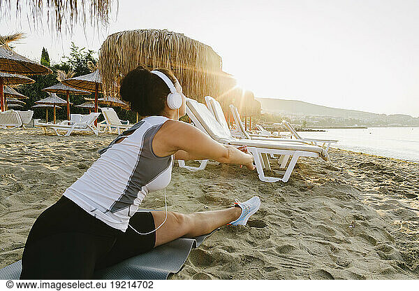 Woman practicing stretching exercise at beach