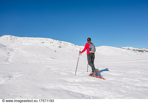 Woman practicing winter sports. Snowshoeing on a sunny day